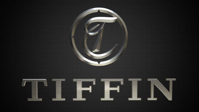 Metallic logo with a stylized letter T inside a circle above the word TIFFIN in bold, shiny letters on a dark, textured background.